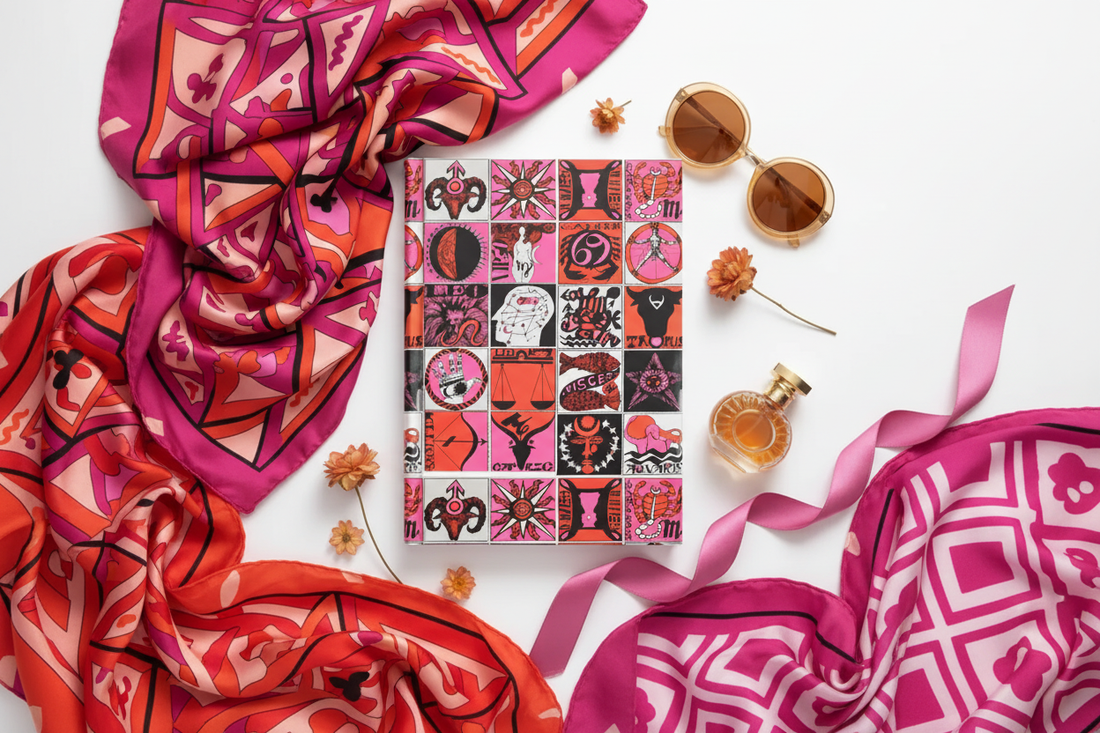 Psychedelic zodiac journal with 12 astrology signs mosaic in pink and red, surrounded by three Pucci-style silk scarves, dried flowers, round sunglasses and vintage perfume bottle - LeBonJournal