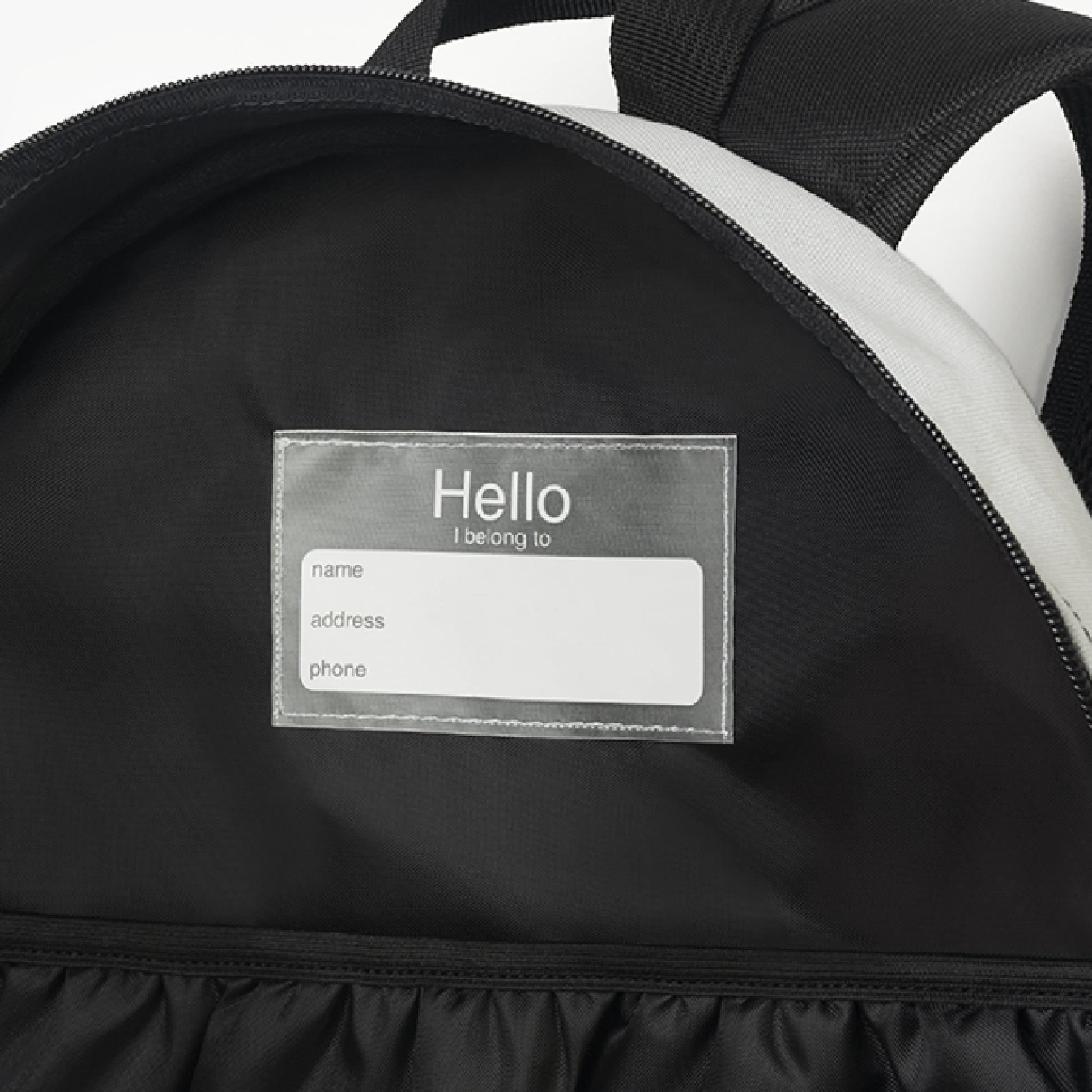 Backpack interior detail showing sewn-in name tag and inner pocket - LeBonJournal