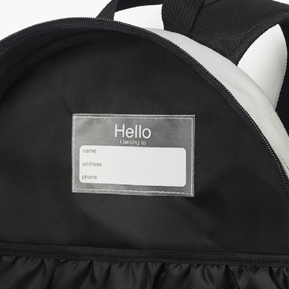 Backpack interior detail showing sewn-in name tag and inner pocket - LeBonJournal