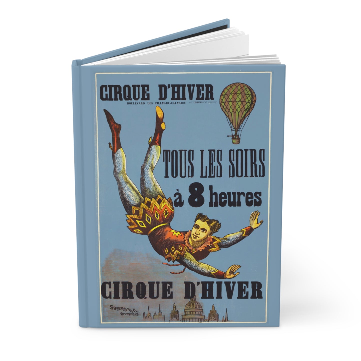 Hardcover circus journal standing upright showing front cover with 1890 Cirque d'Hiver Paris poster featuring aerialist floating above Parisian skyline with hot-air balloon on matte finish cover - LeBonJournal