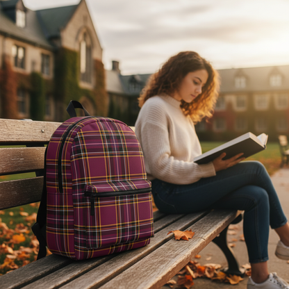 Plaid burgundy backpack on campus bench with student reading in background autumn afternoon - LeBonJournal