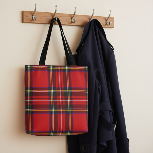 Red tartan tote bag hanging on wooden coat rack next to navy trench coat in warm library setting - LeBonJournal
