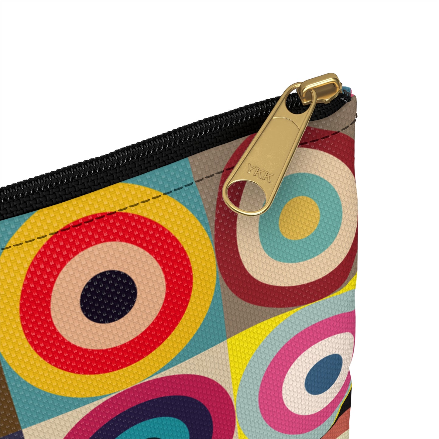Close-up detail of black zipper and gold puller on retro circles accessory pouch with colorful geometric pattern - LeBonJournal
