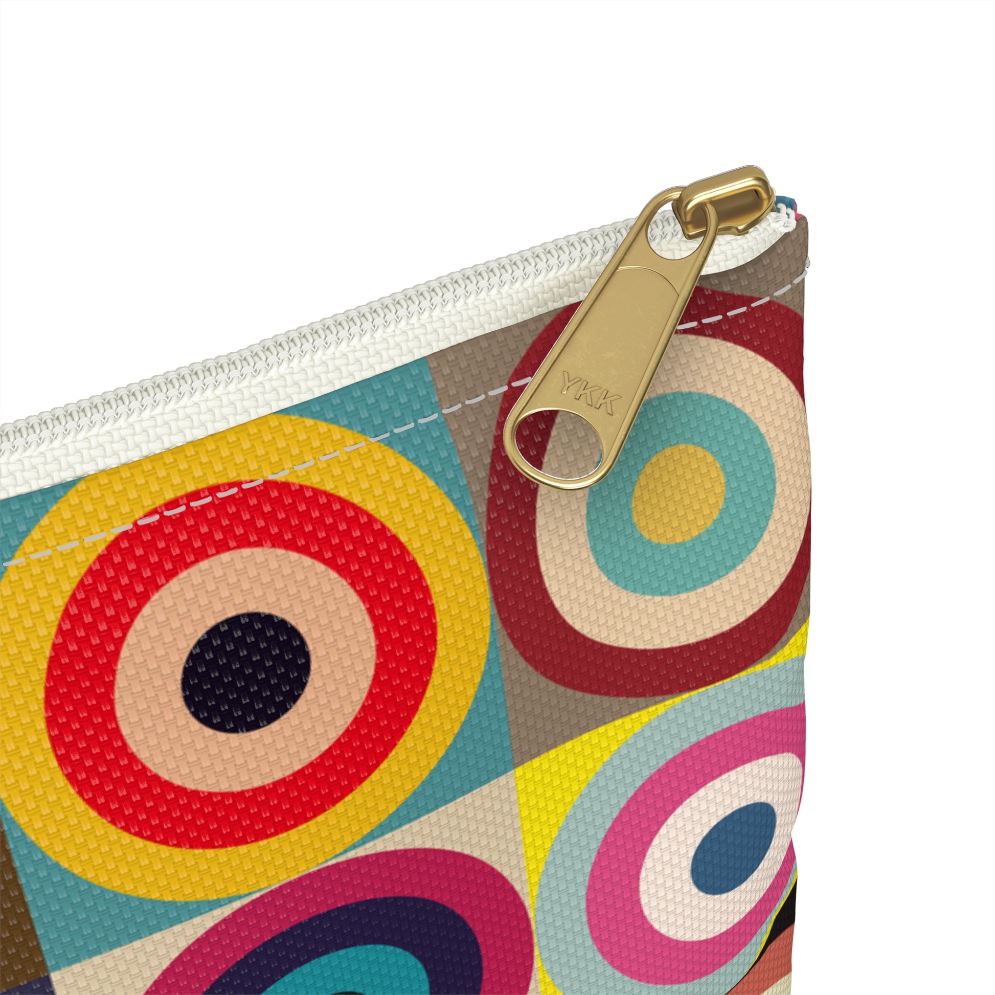 Close-up of white zipper and gold puller on retro circles accessory pouch showing vibrant concentric circles pattern - LeBonJournal