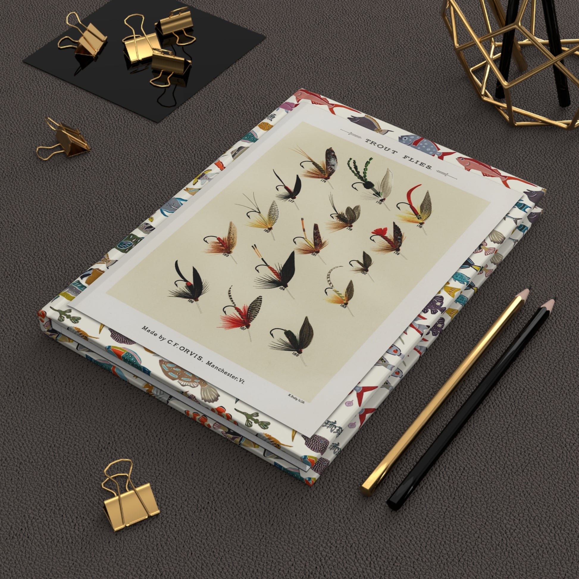 Mary Orvis Marbury 1892 trout flies journal on desk with gold clips for fishing logs . LeBonJournal